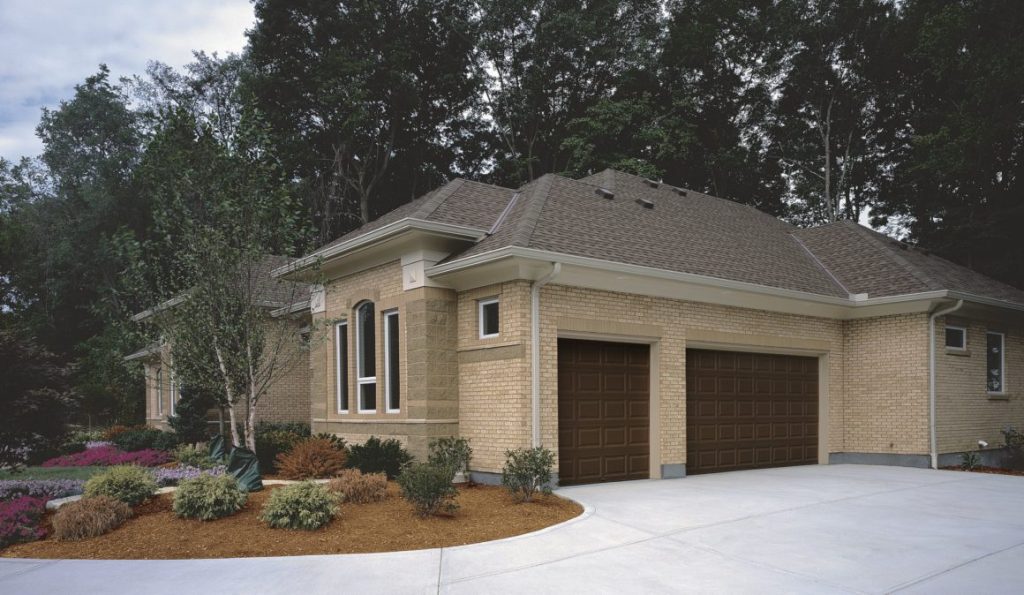 Beige home with two dark brown garage doors