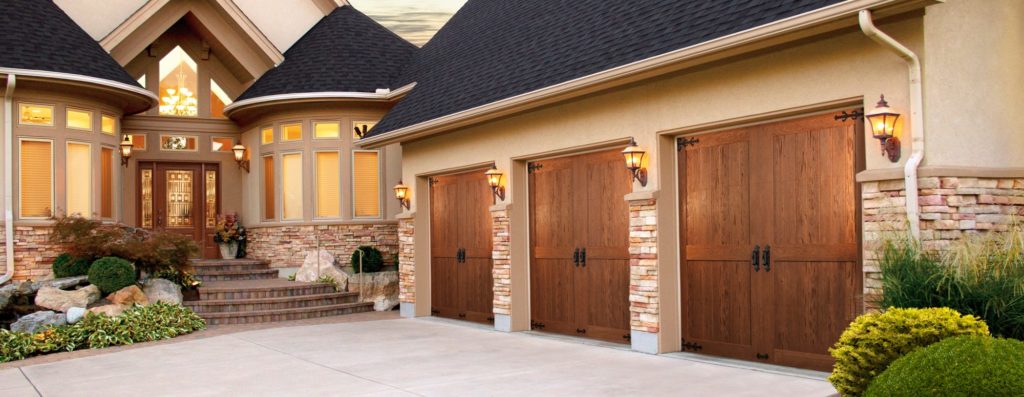 Large tan house with three wooden garage doors